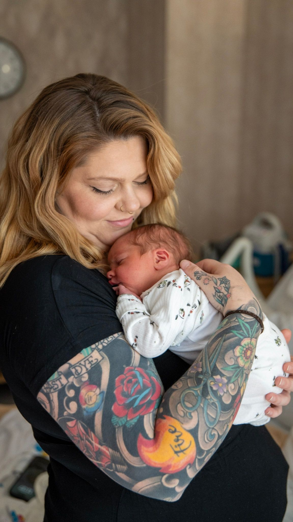 Series of intimate moments between a person with tattoos and a swaddled newborn.