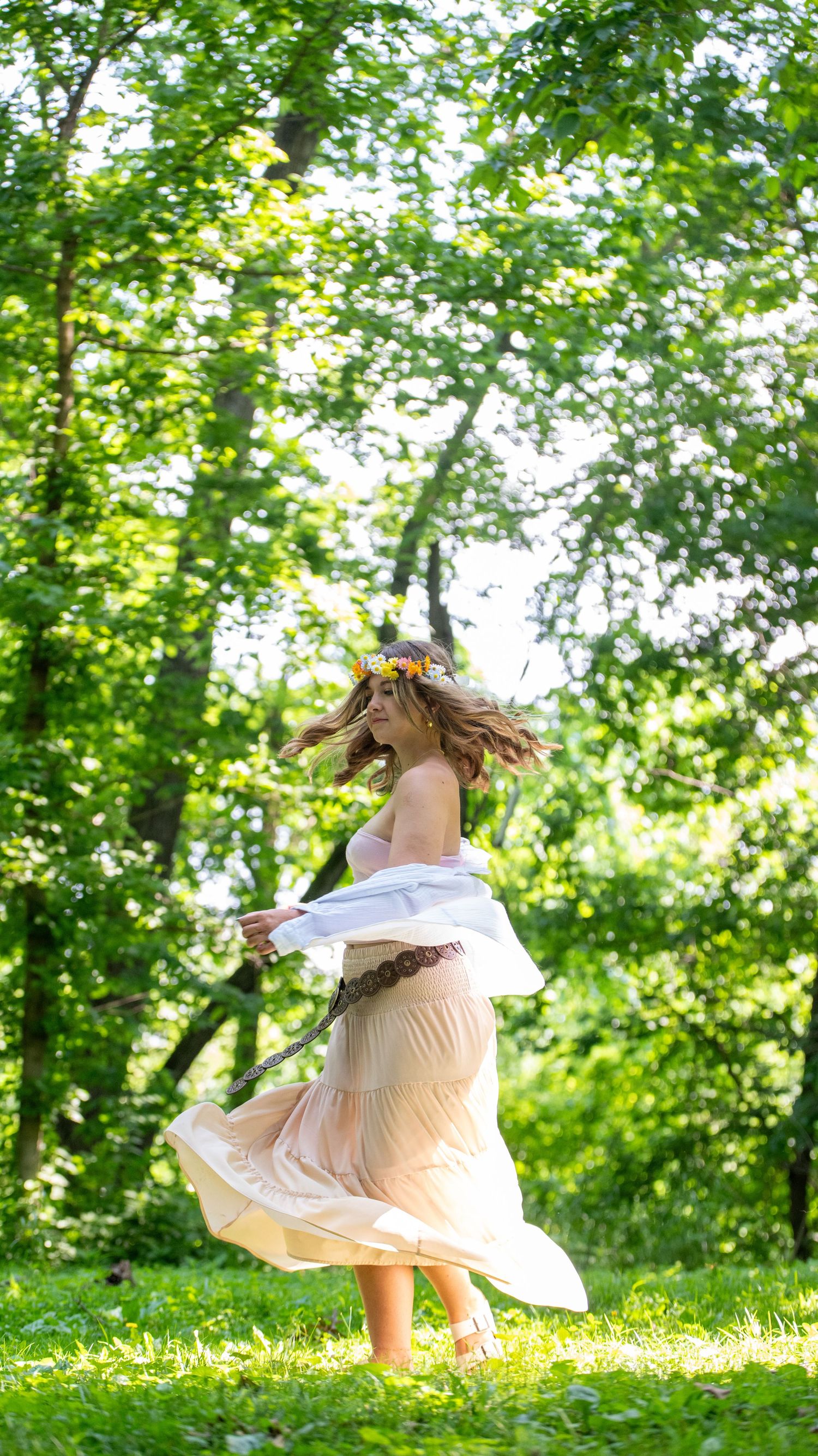 Whimsical sequence of dancing in a white dress among sunlit trees and grass.