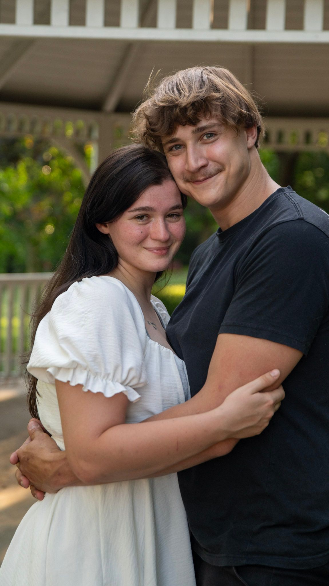 A series of embraces captured under a covered porch in natural lighting.