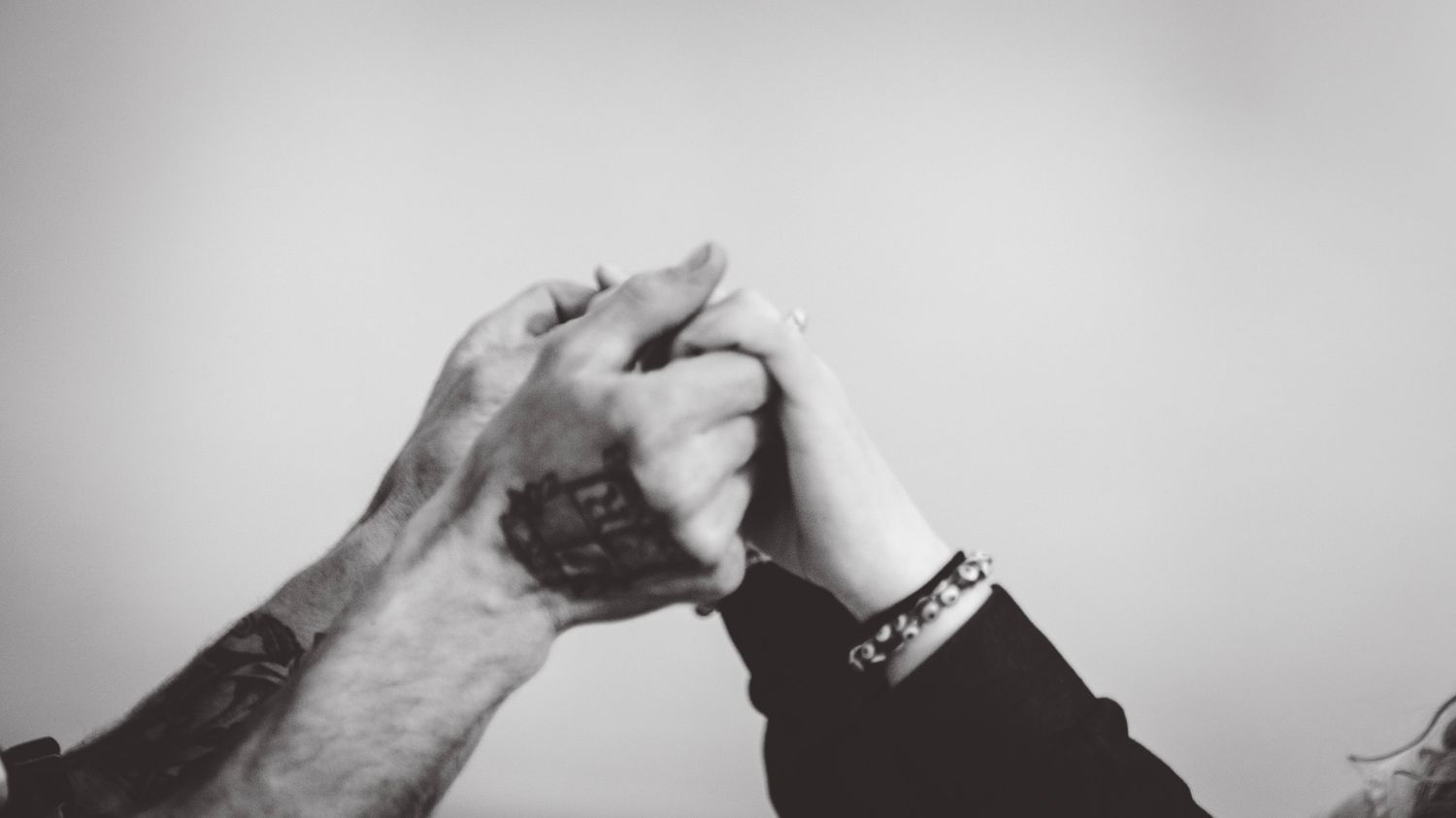 Black and white close-up shots of intertwined hands showing connection and intimacy.