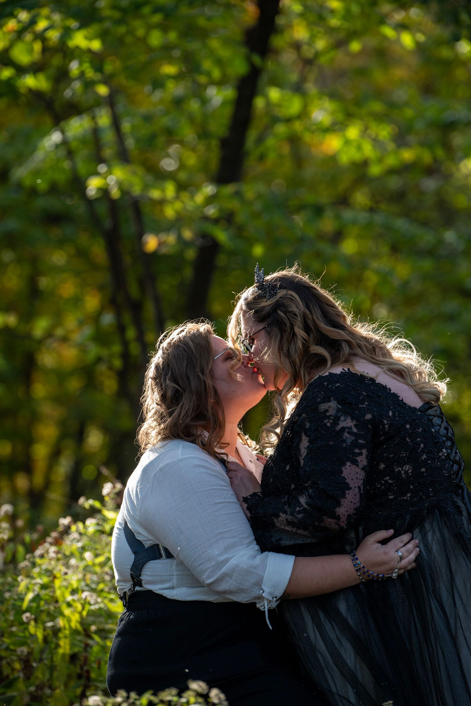 Intimate moment captured between couple in formal wear surrounded by autumn foliage.