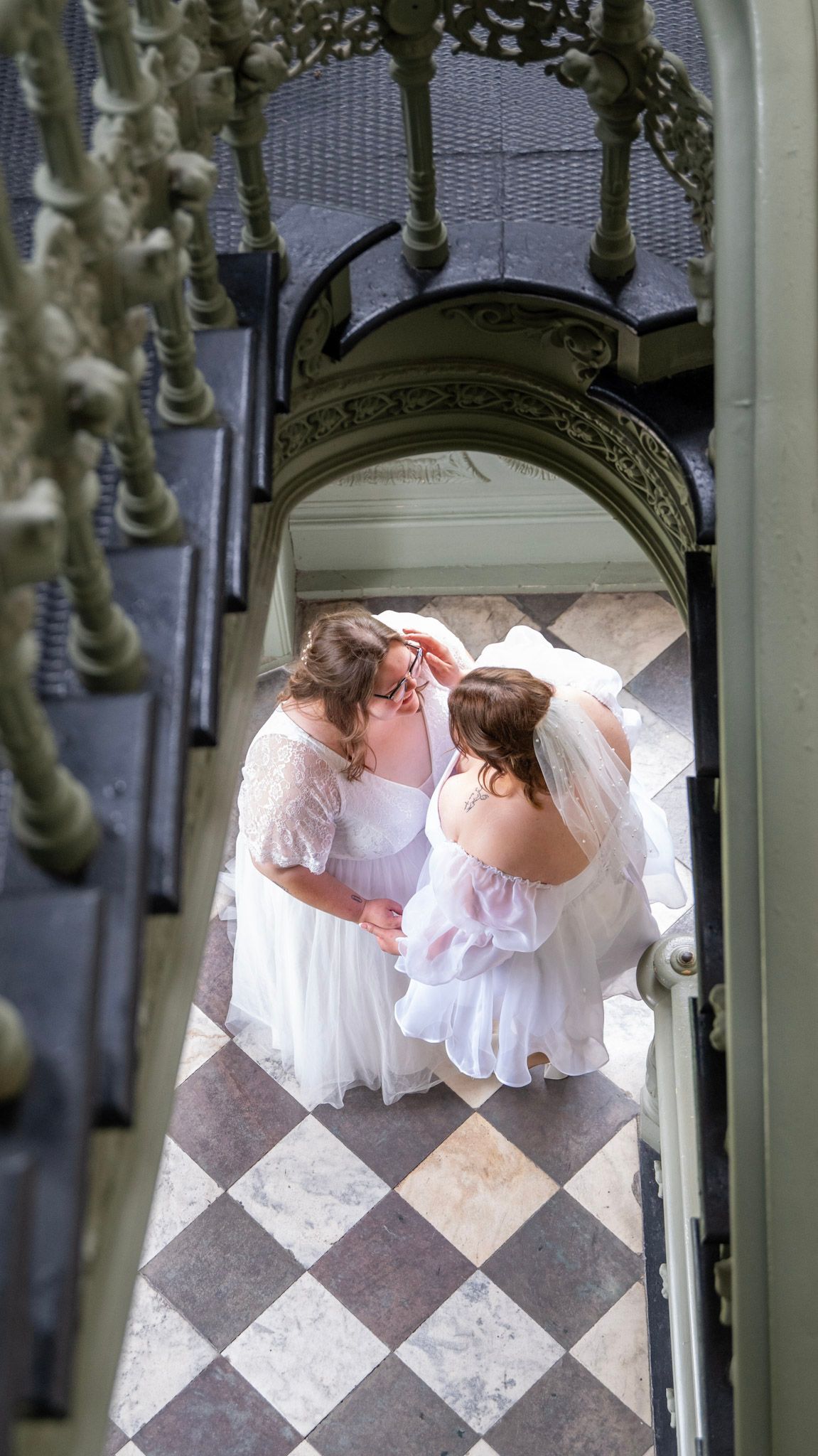 Birds-eye view of wedding moment captured through decorative staircase railings.