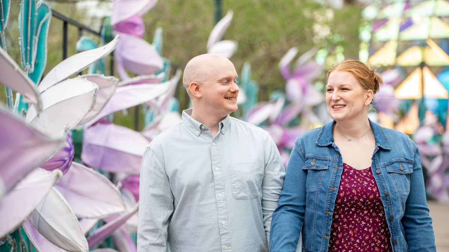 A couple sharing a joyful moment together at an outdoor festival with decorative banners.