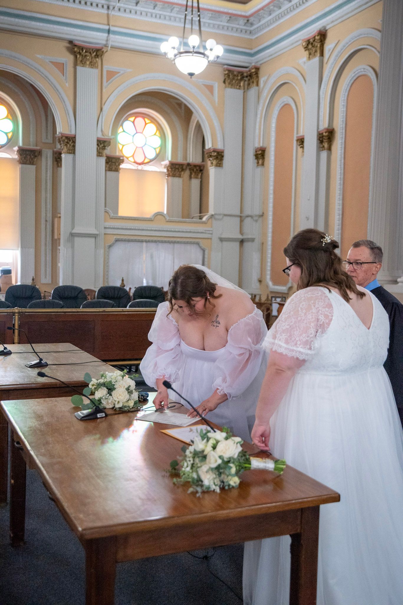 Wedding ceremony proceedings at a wooden table in an ornate church sanctuary.