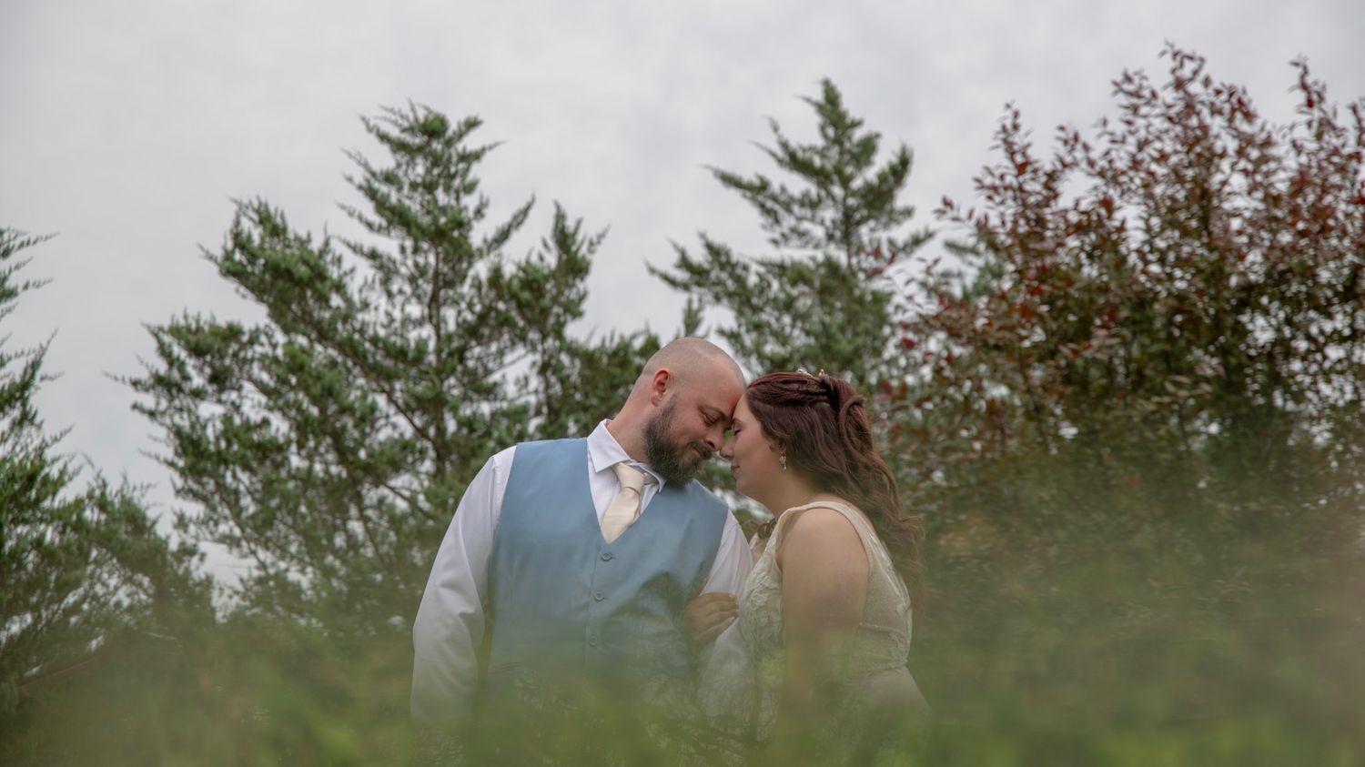 Wedding photo series featuring a couple posing in front of rustic buildings and green landscapes.