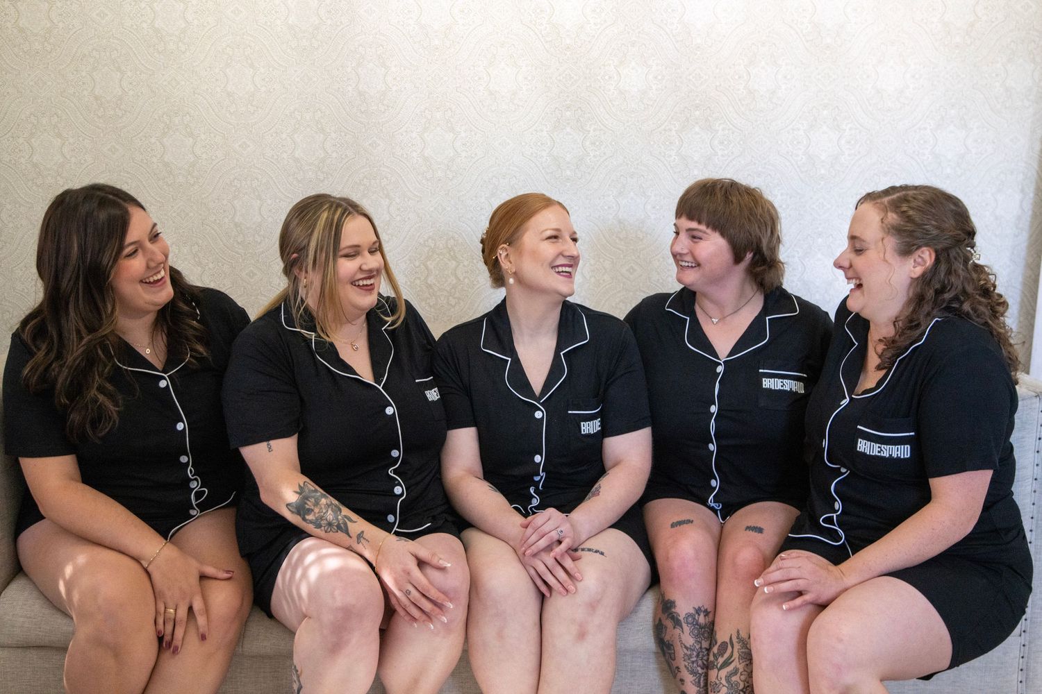Group wearing matching black pajamas sitting together in casual pose.