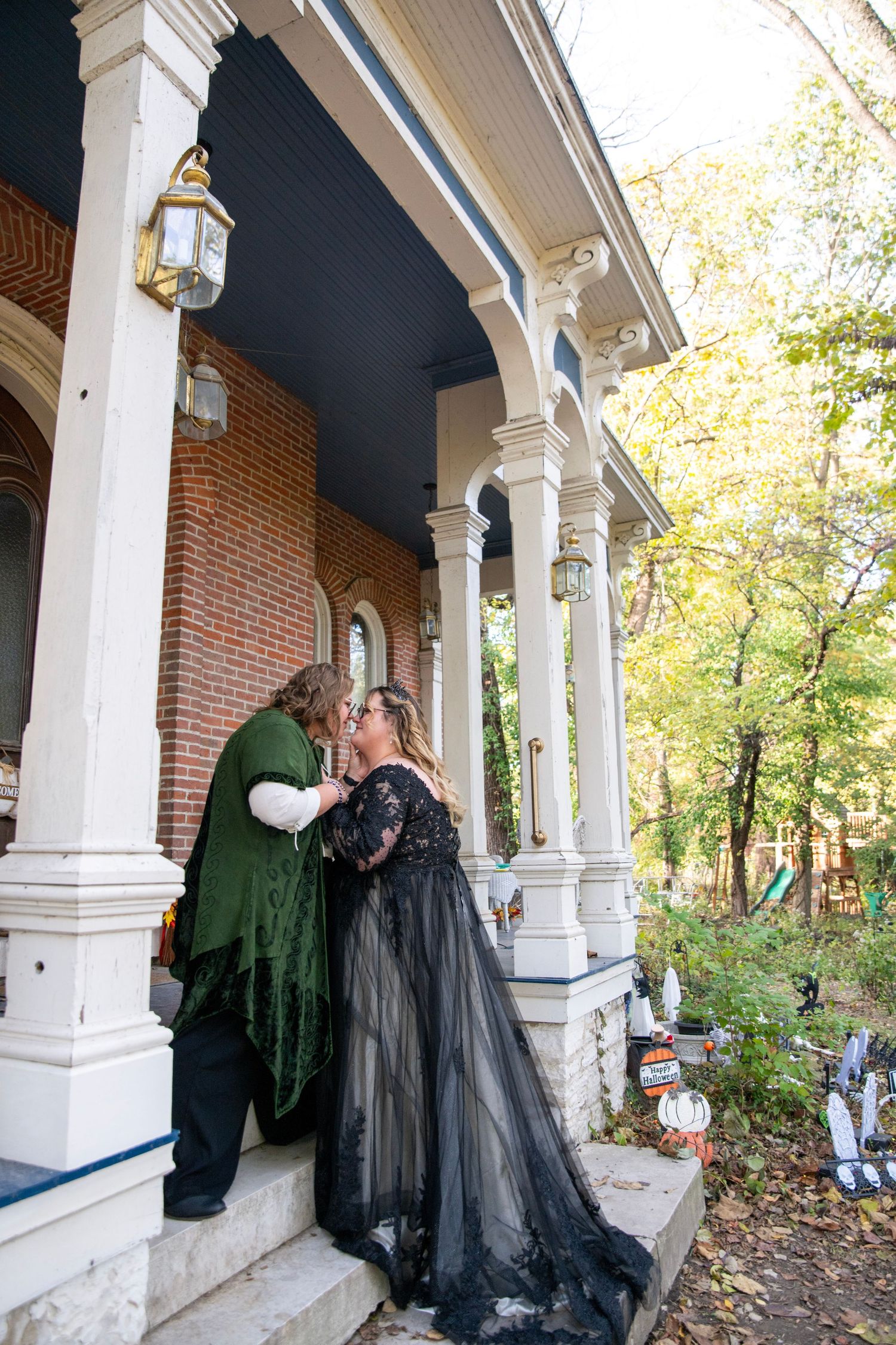 Candid moments captured on an ornate Victorian porch with white columns and brick details.
