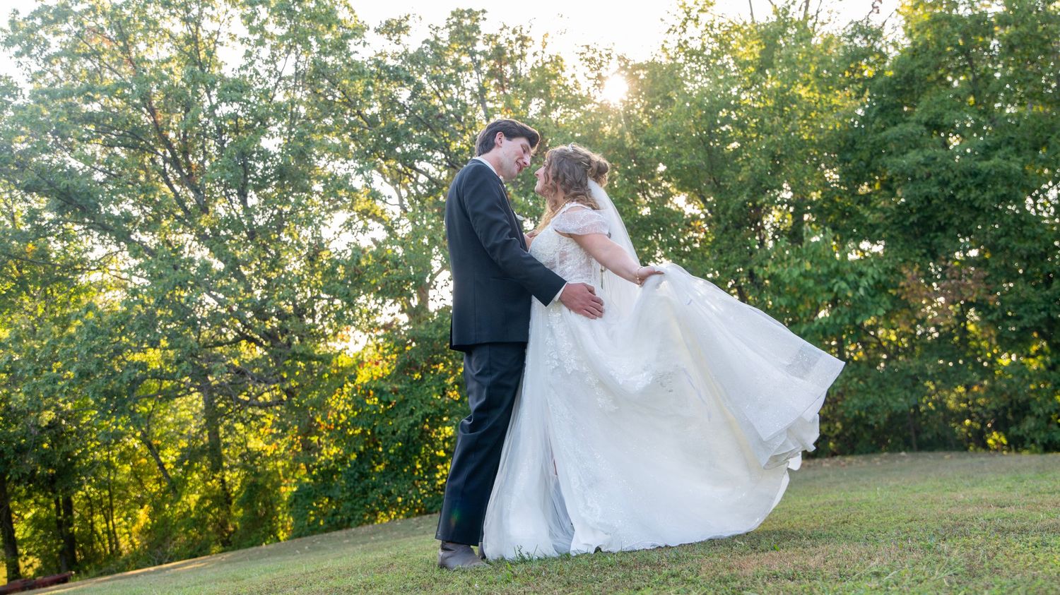 Romantic wedding couple embraces in a series of poses against a lush green outdoor backdrop at sunset.