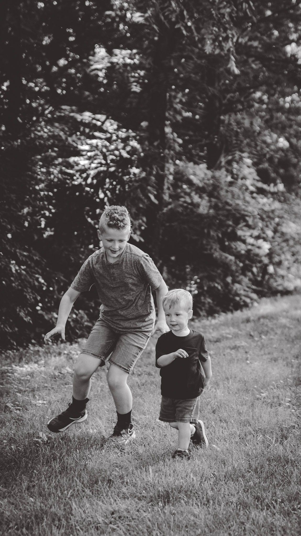 Black and white action shots of playful moments on a grassy hillside.