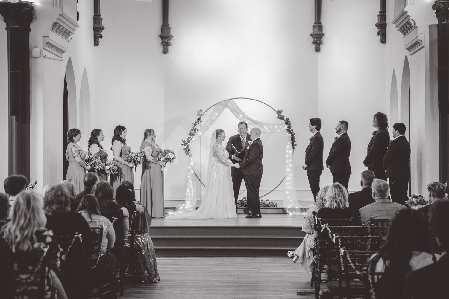 Wide angle view of wedding ceremony in traditional church sanctuary.