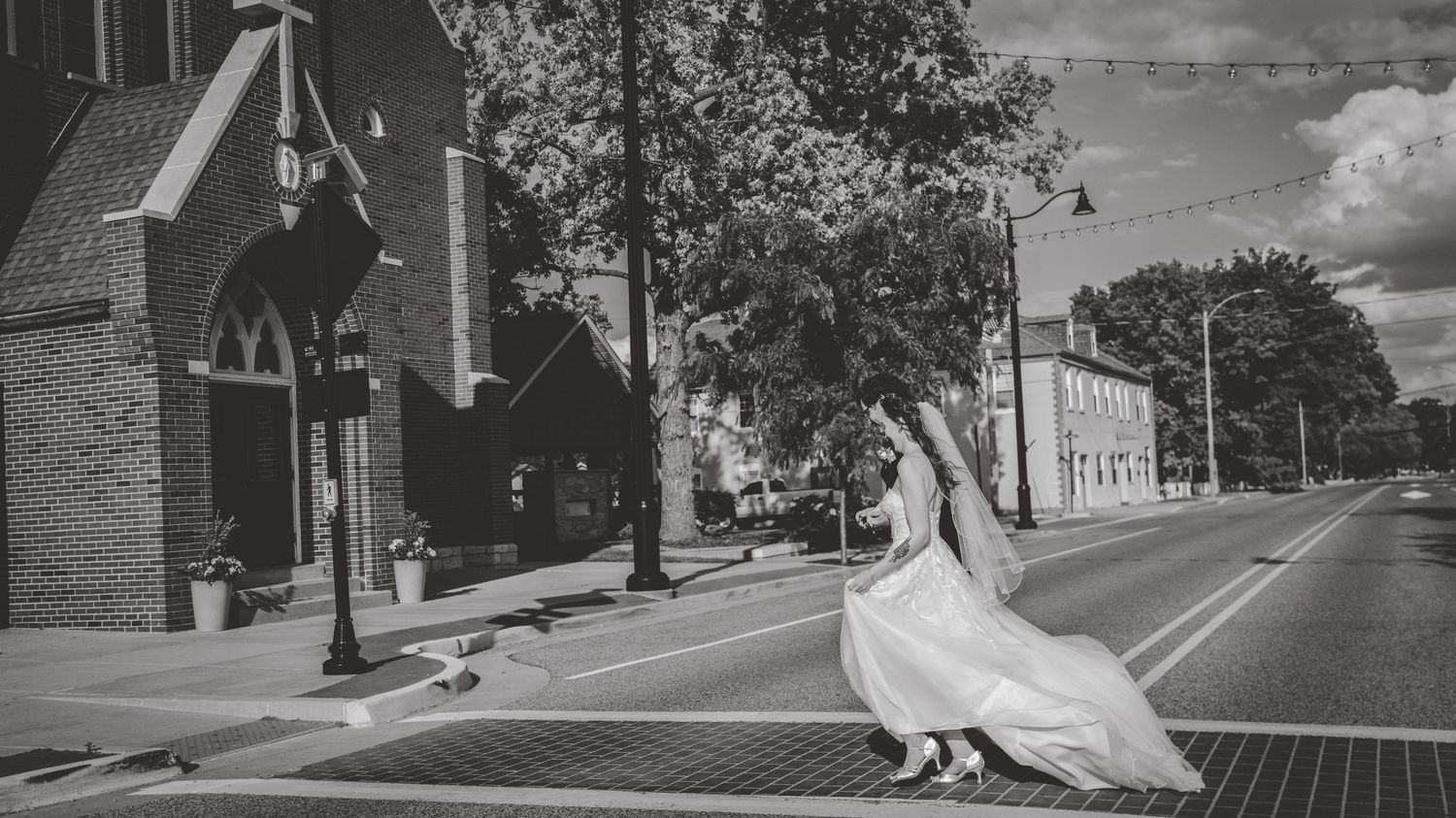 Black and white panoramic cityscape with wedding party silhouettes.