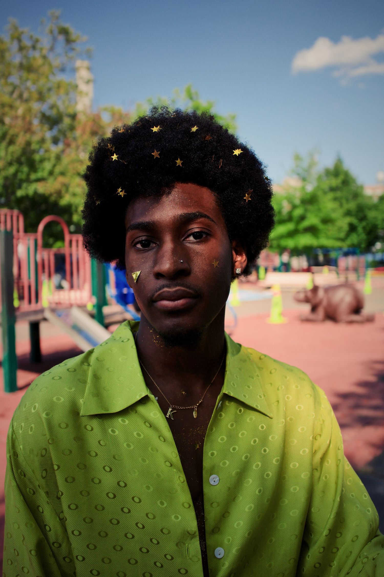 Outdoor portrait in a bright lime green shirt at a playground.