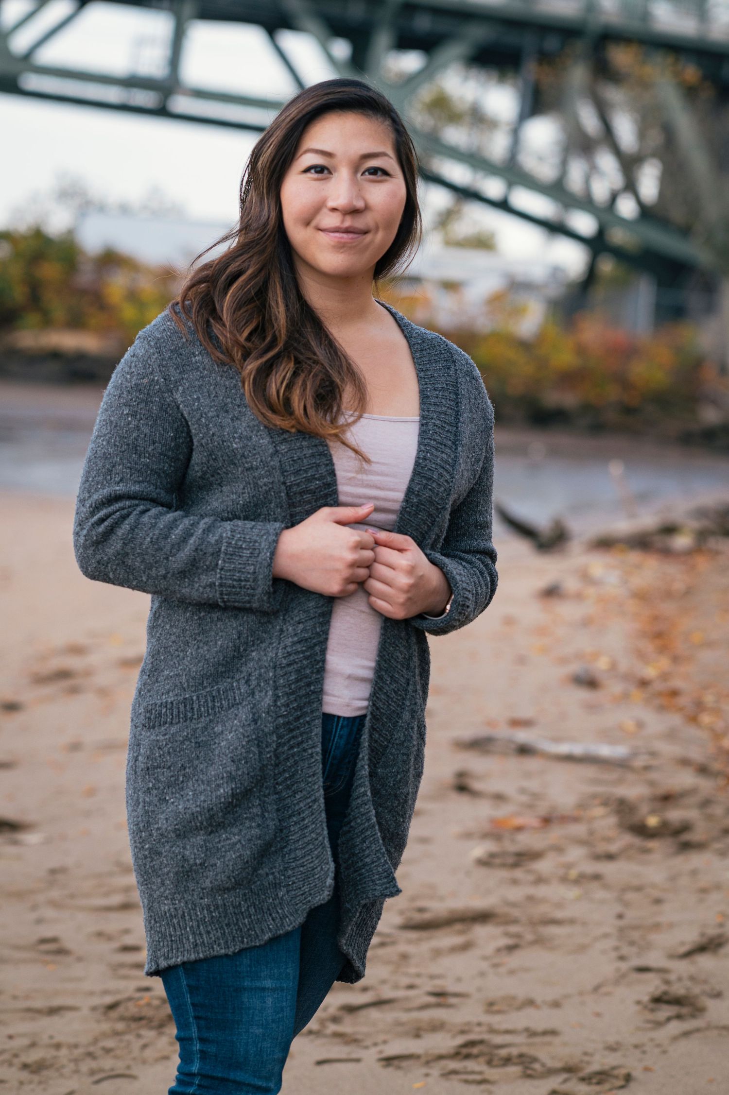 Casual portrait series on beach with woman wearing gray cardigan and jeans.
