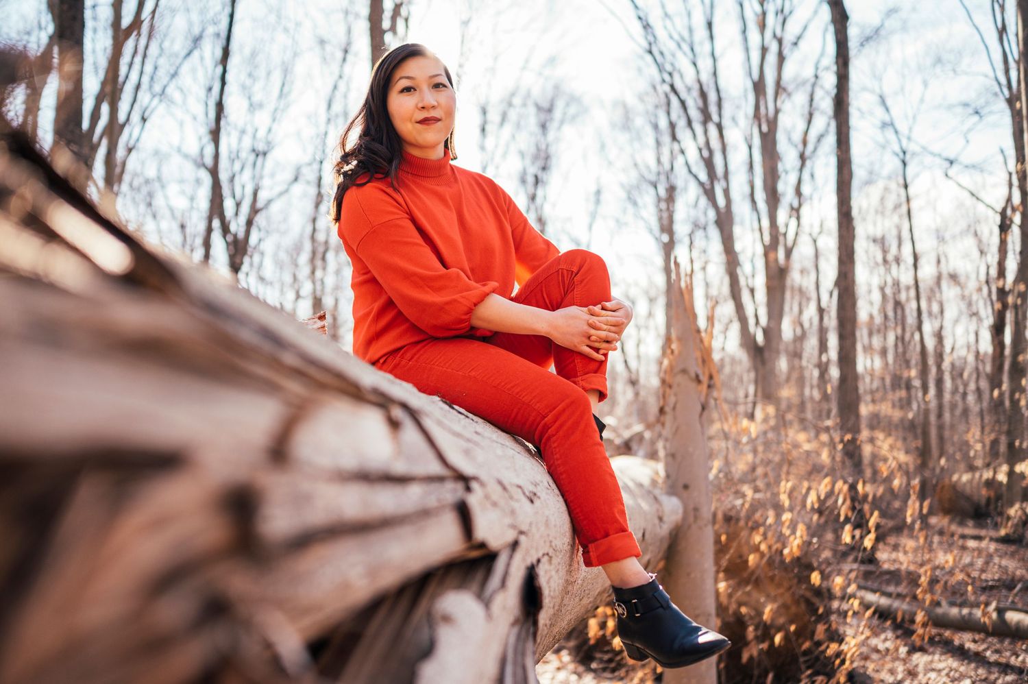 Person in bright red coat posing outdoors during autumn.