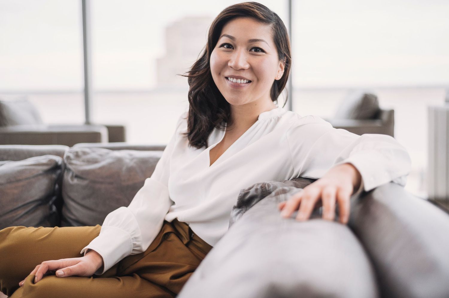 Relaxed indoor lifestyle portrait on couch in white clothing.