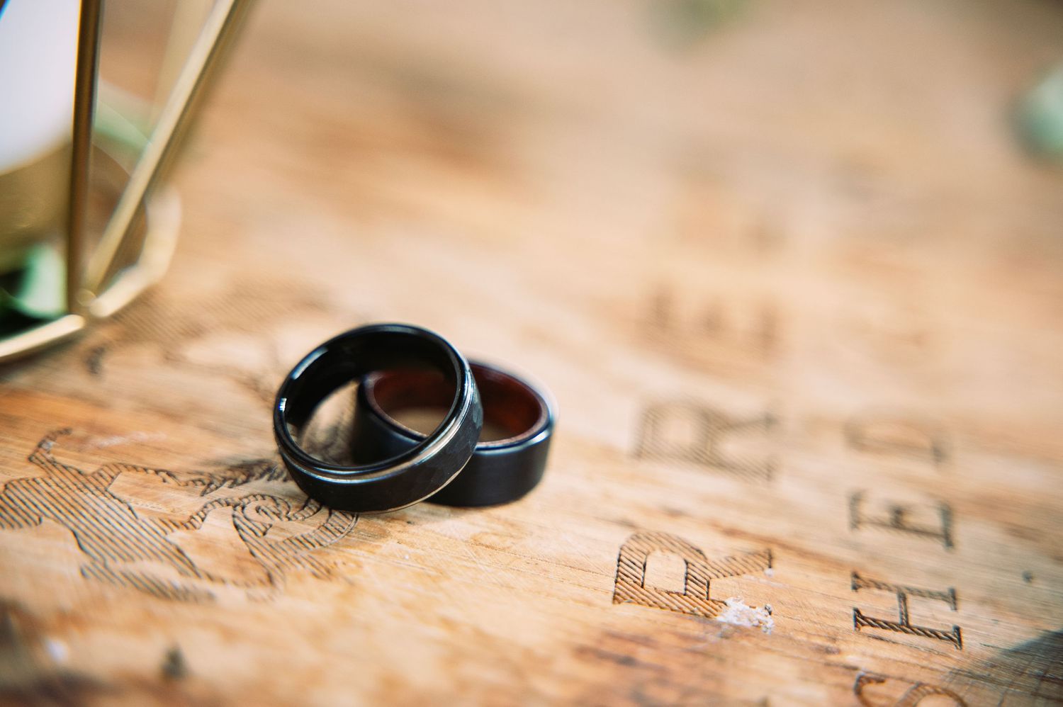 Two wedding rings rest on a vintage map creating a romantic travel-themed wedding detail shot.