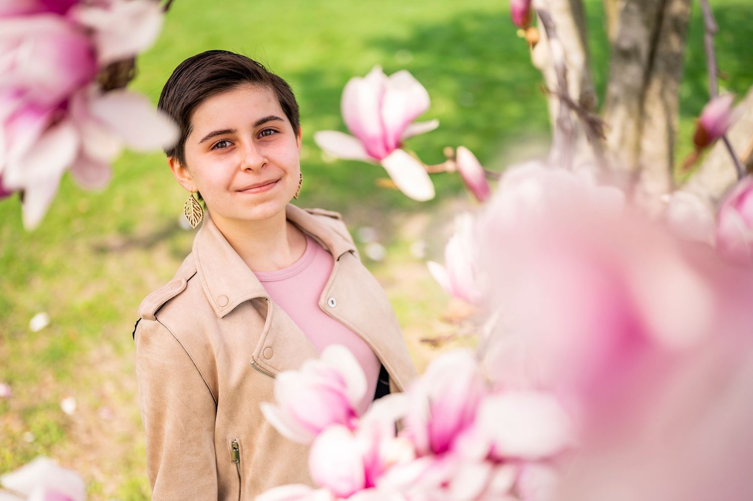 Spring portrait with pink magnolia blossoms in soft focus.