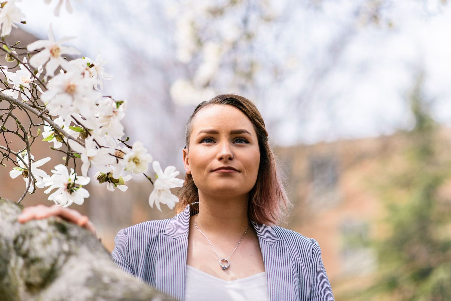 Spring portrait with cherry blossoms in soft focus background.