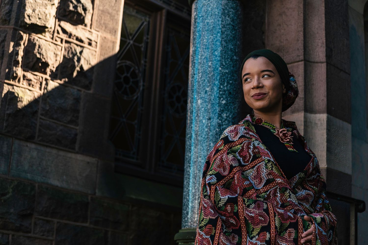 Architectural portrait with dramatic shadows against stone building.