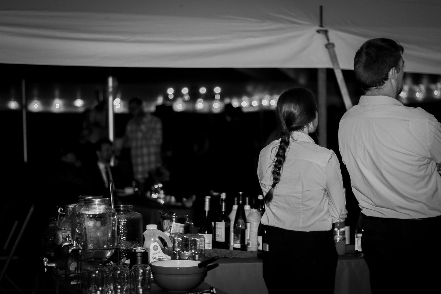 Silhouettes of vendors standing in a dimly lit indoor event space.