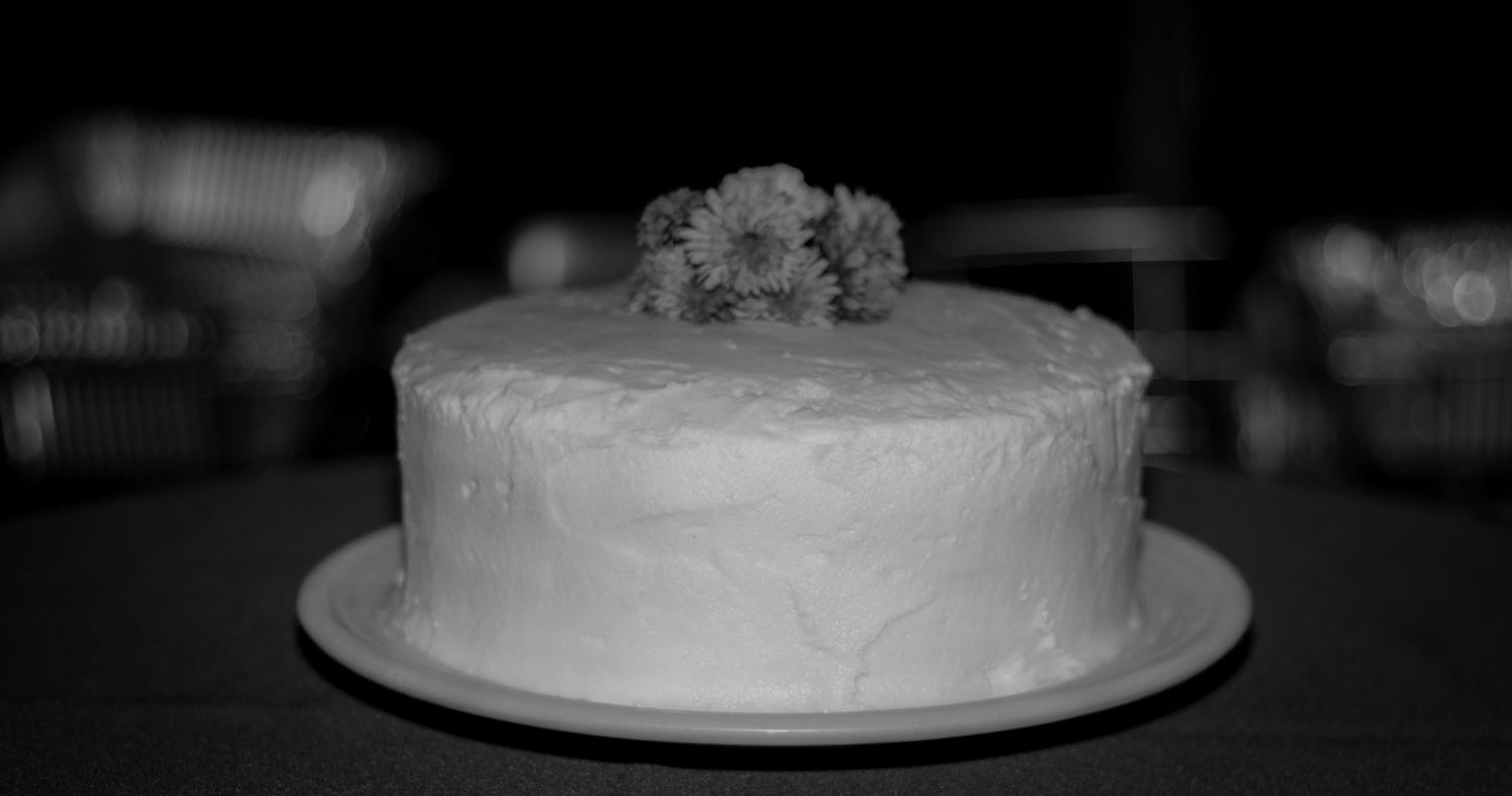 Close-up of an elegant white wedding cake with floral decorations.