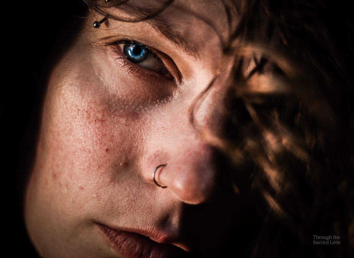 Artistic close-up portrait shots in dramatic lighting highlighting blue eyes and facial features.