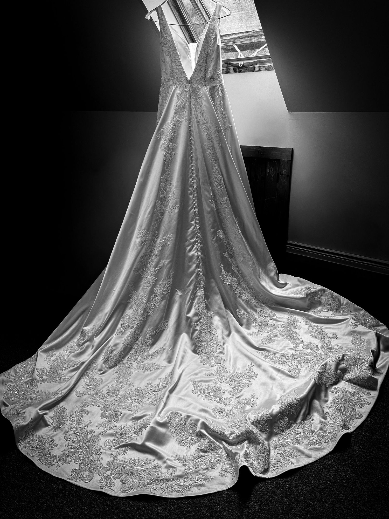 Detailed view of an elegant white wedding dress train with intricate lace patterns.