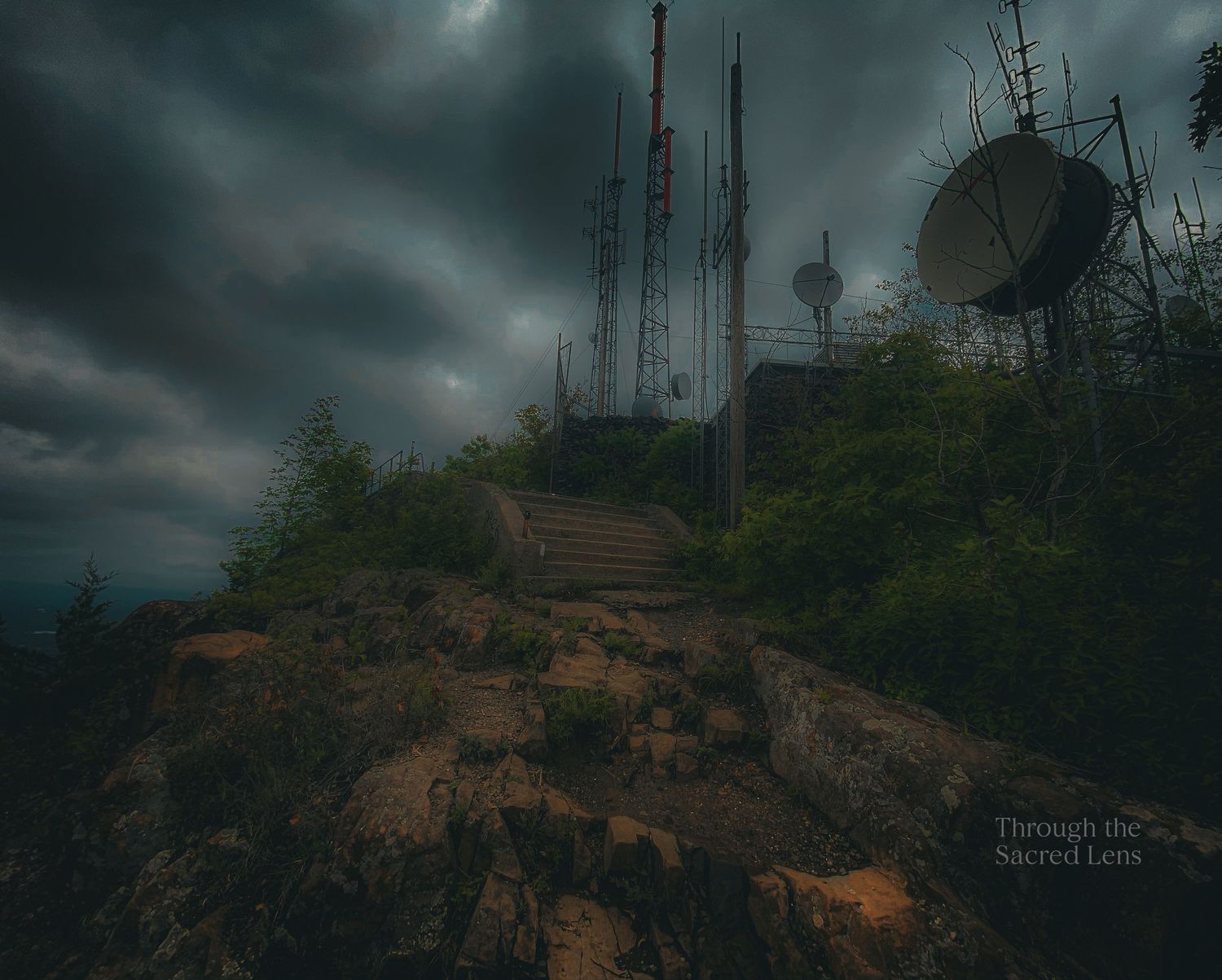 Ominous storm clouds gather over communication towers on a mountain top..
