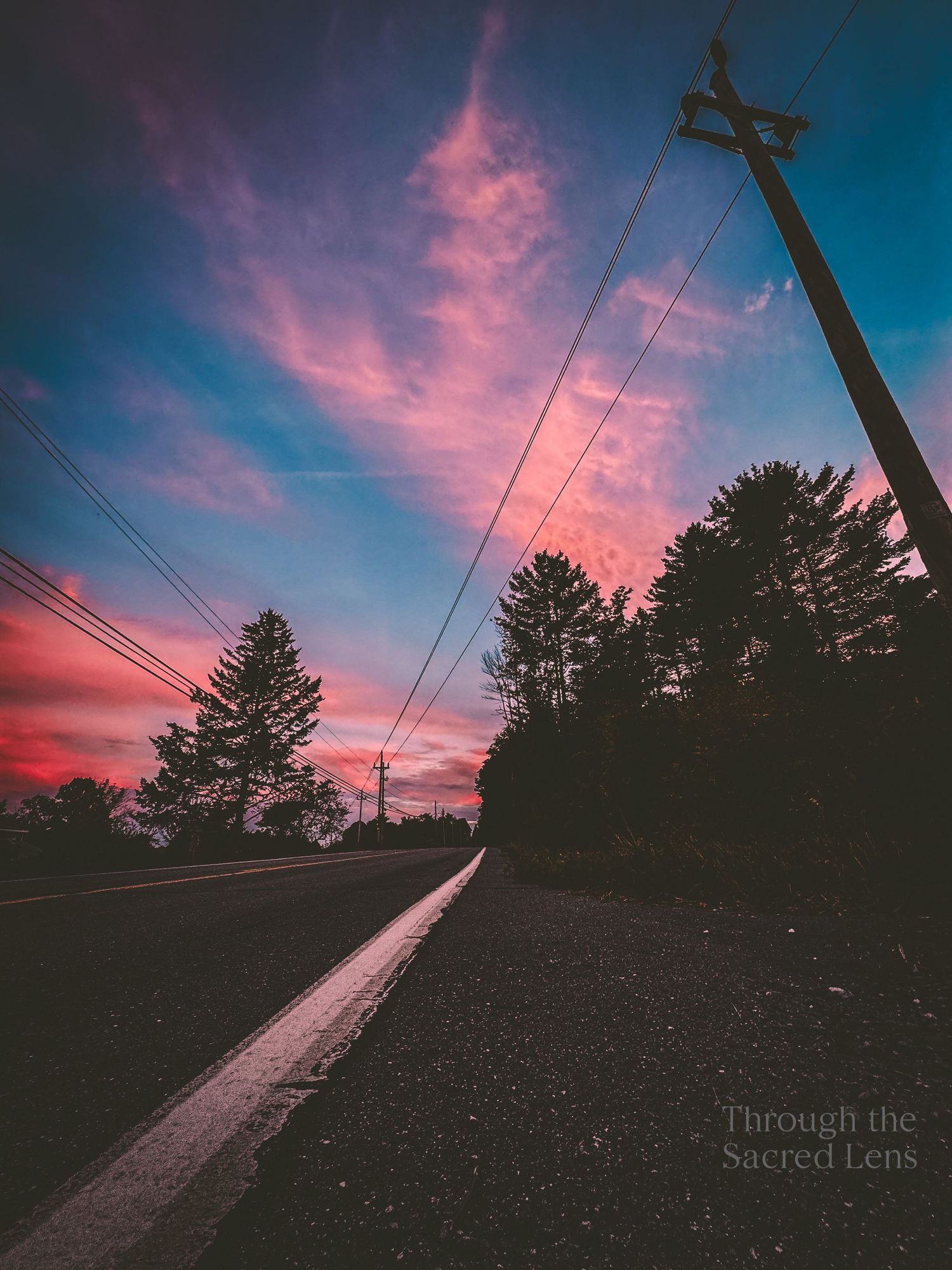 Dramatic pink and purple sunset sky against a darkening landscape.