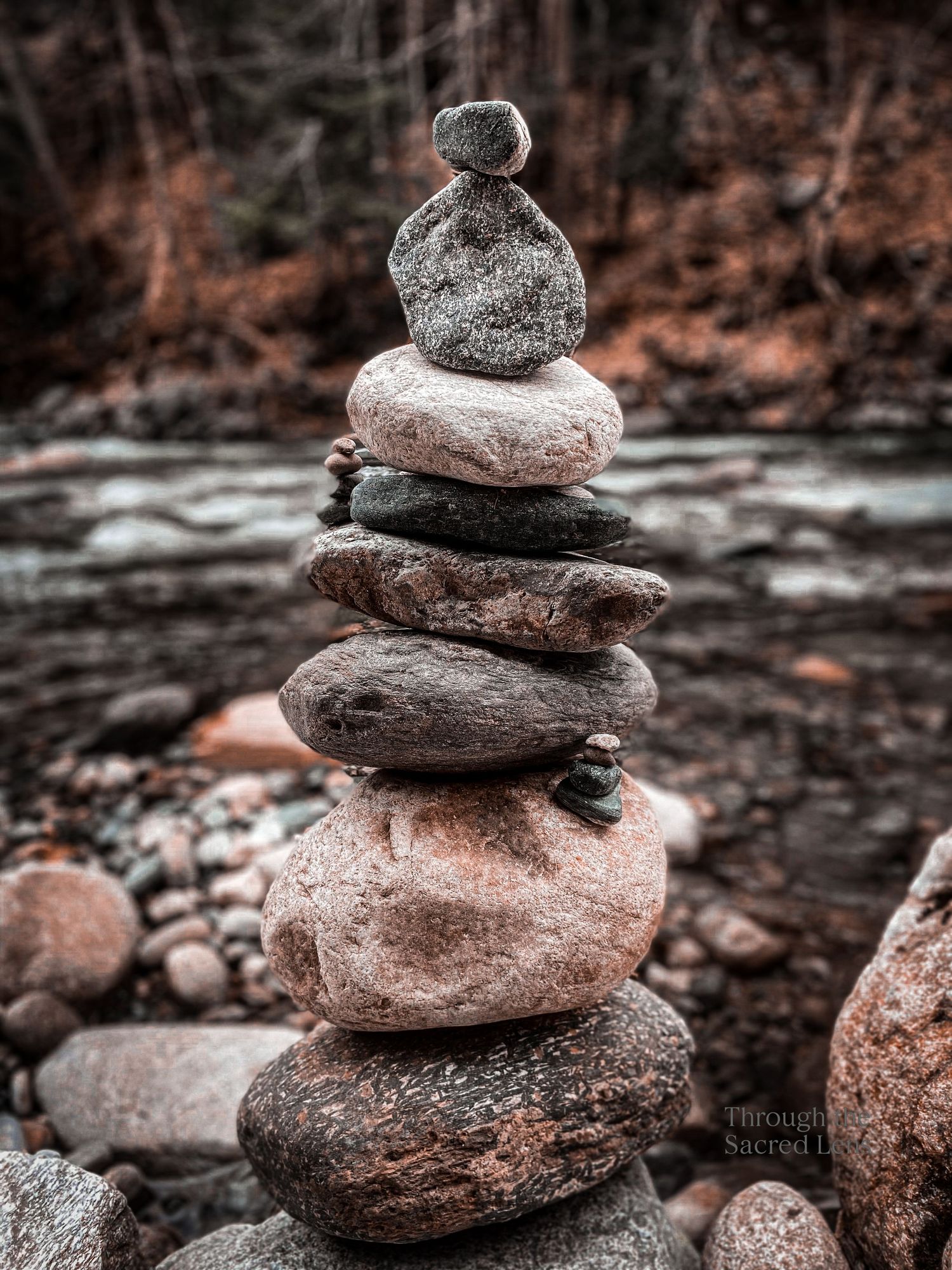 Carefully balanced stack of smooth river rocks creating a zen cairn formation.