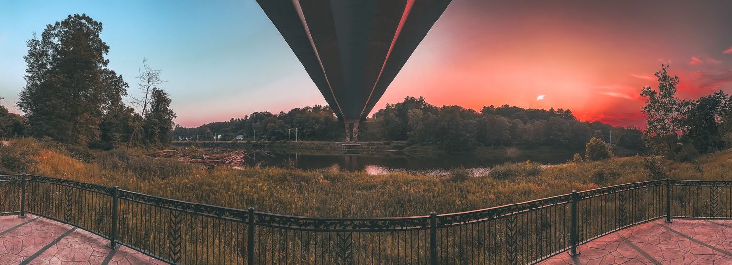 Wide panoramic sunset view with dramatic orange and pink clouds stretching across the horizon.