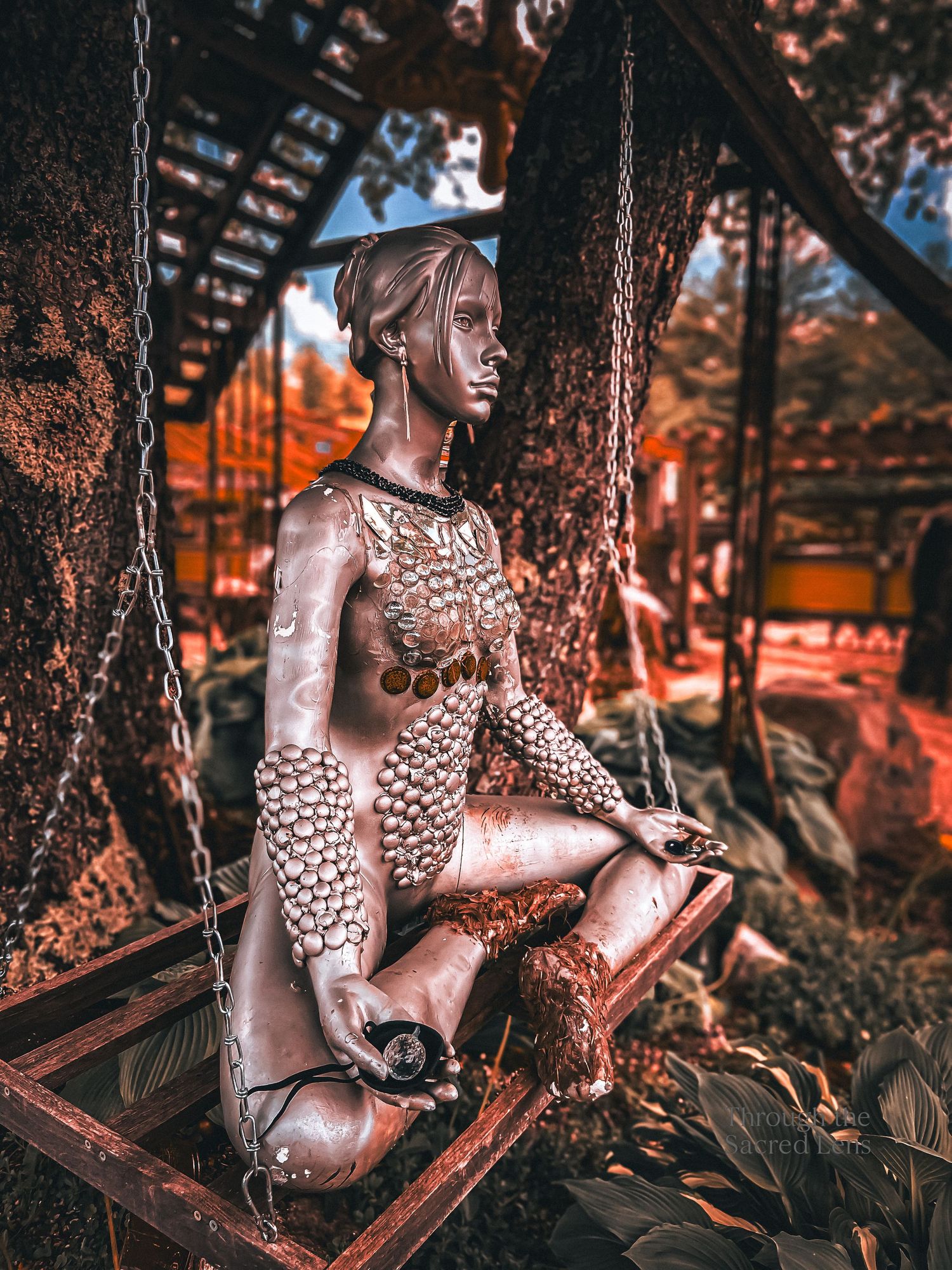 Artistic statue among trees in warm autumn lighting.
