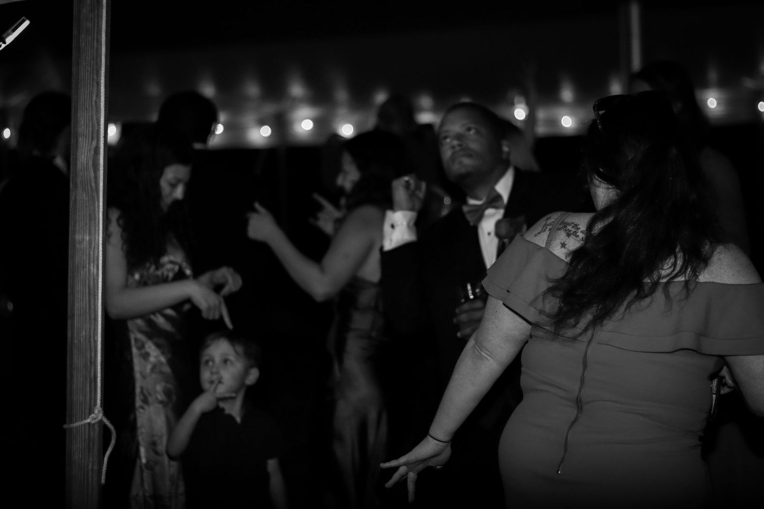Dimly lit dance floor scene with string lights in the background.