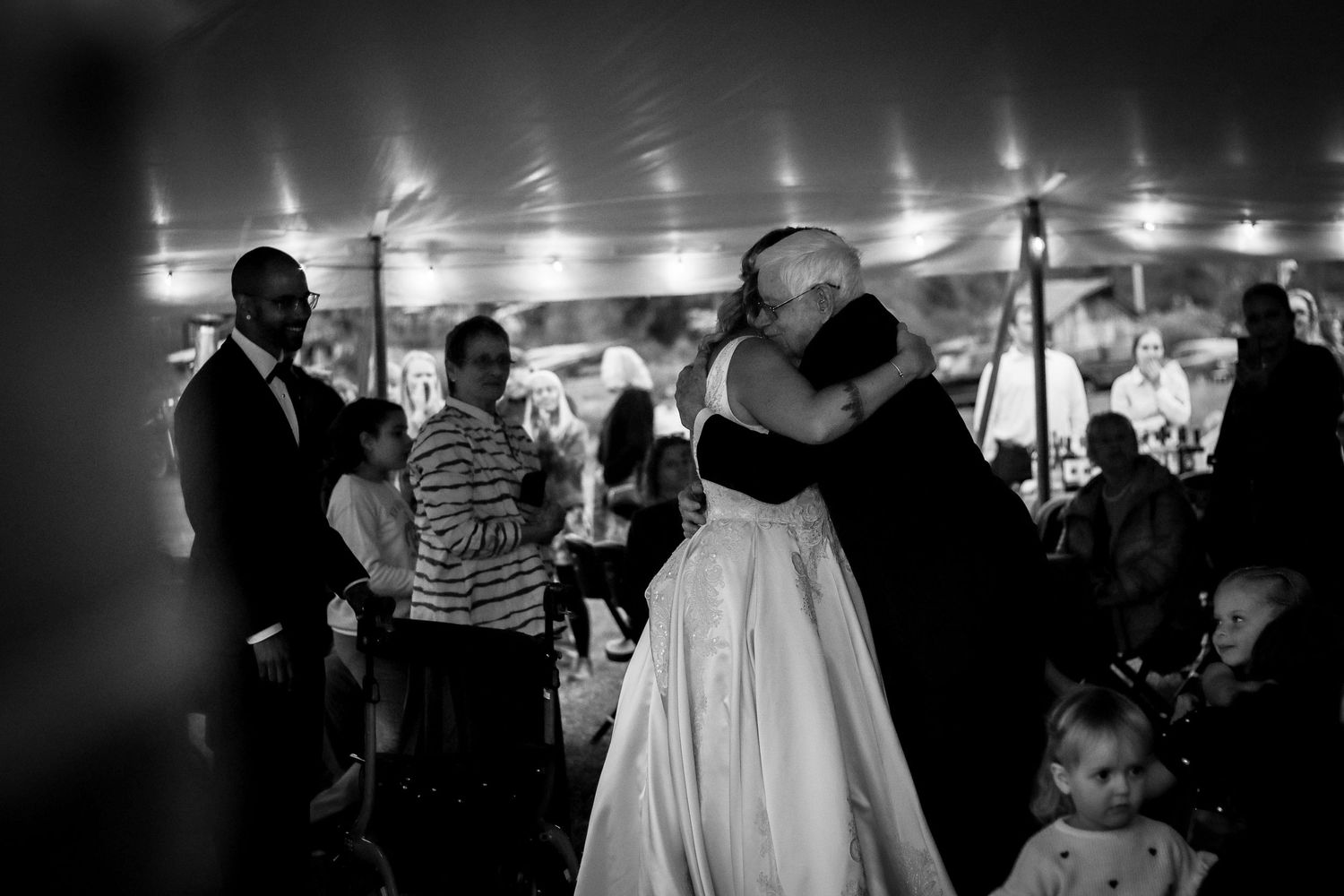 Intimate dance moment captured under tent lighting at wedding reception.