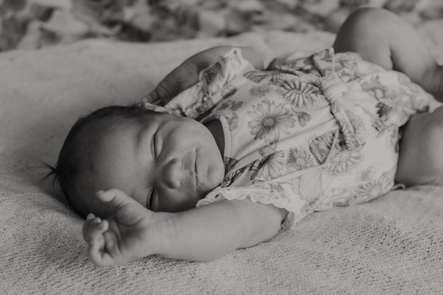 Black and white series showing peaceful sleeping newborn in natural poses.