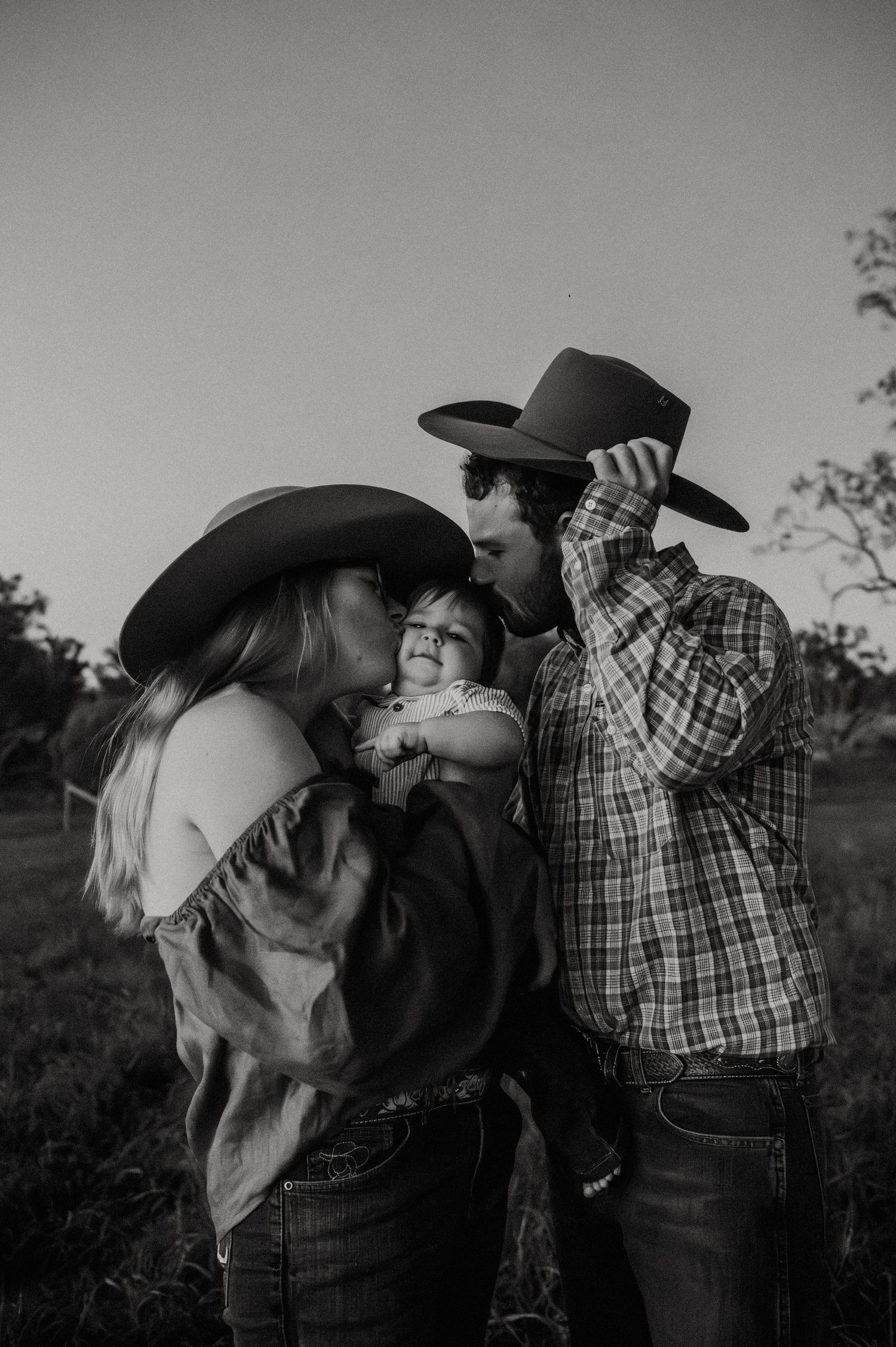 A romantic black and white photo sequence showing a couple sharing tender moments in cowboy hats and western attire.