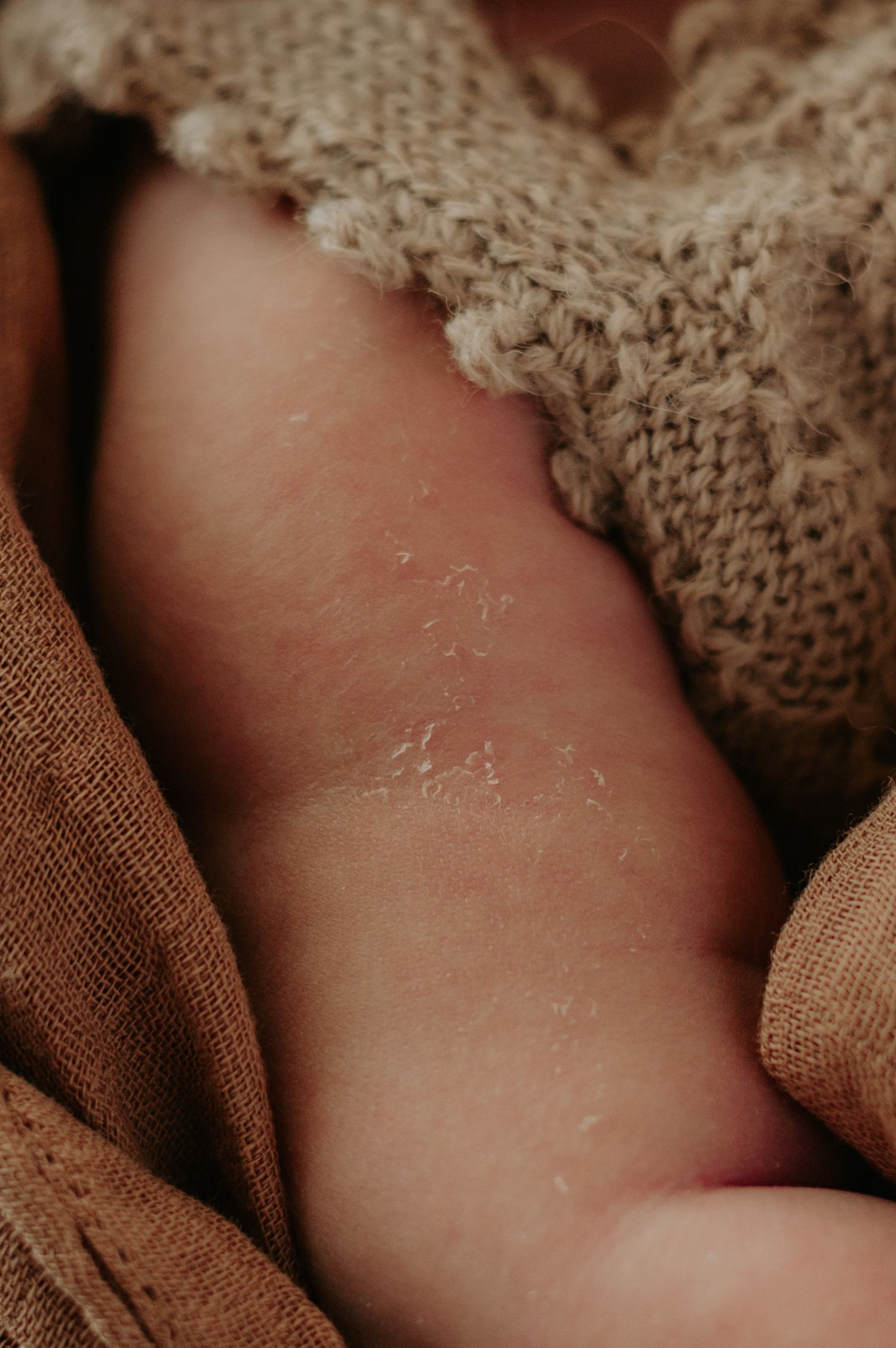 Close-up macro shot of knitted beige fabric texture showing intricate stitch patterns and natural fibers.