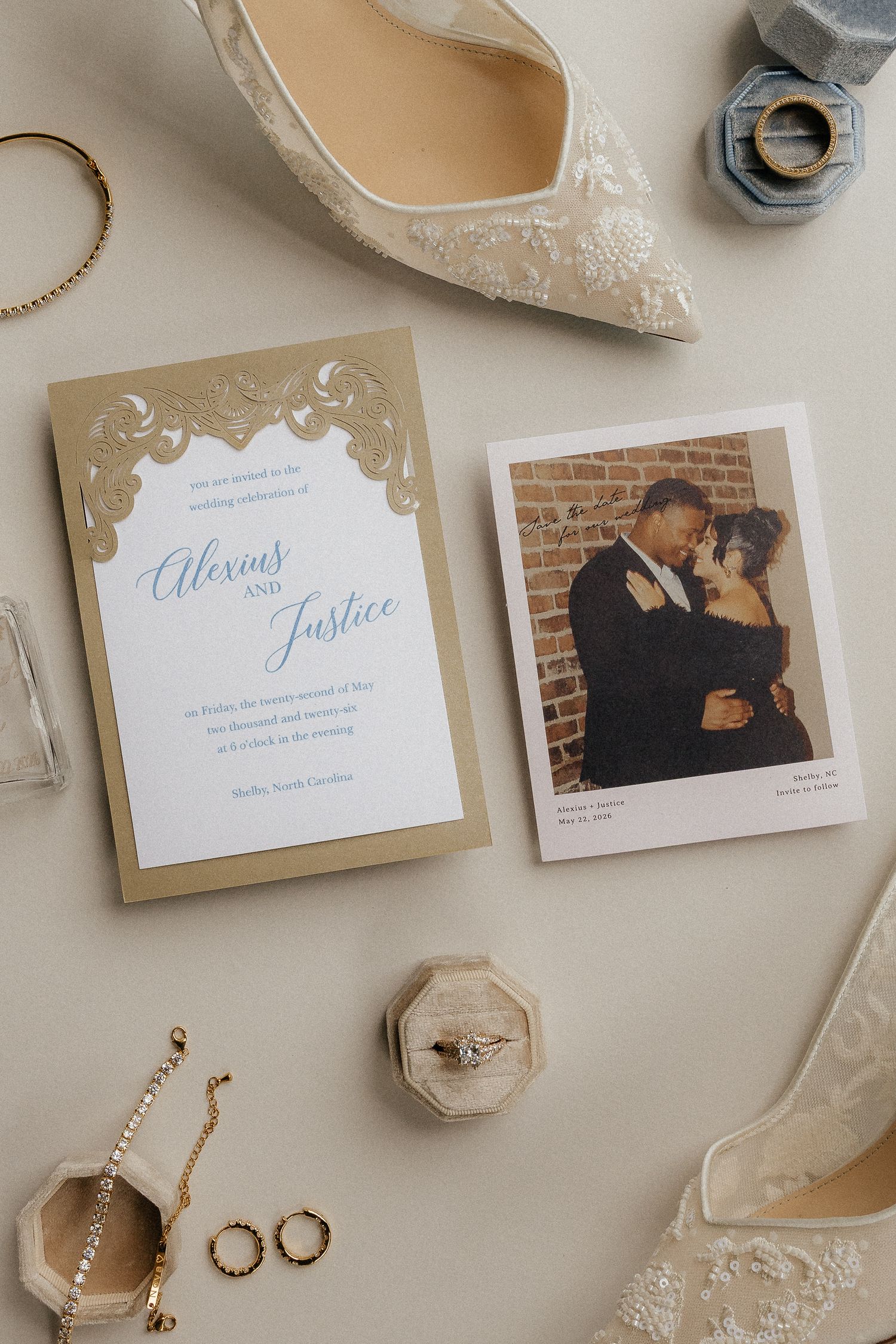 Wedding invitation suite for Alexius and Justice displayed with bridal accessories, lace heels, jewelry, and an engagement photo.
