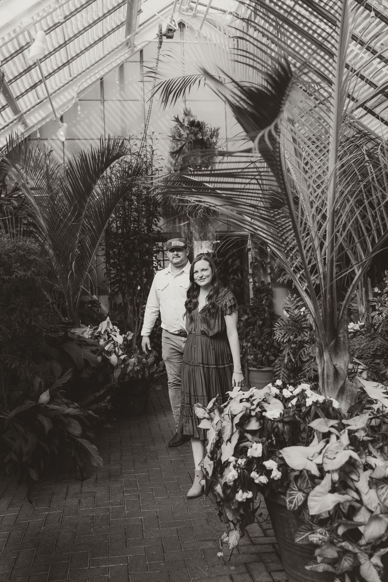 A sequence of vintage black and white photographs showing a person sitting in a greenhouse or conservatory with tropical plants.