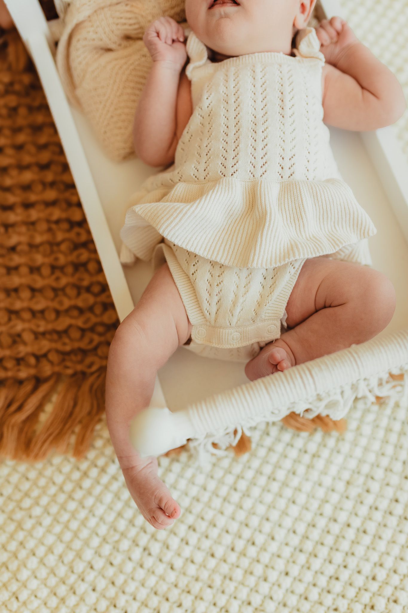 Bradenton in-home newborn photography featuring parents cuddling their newborn in a cozy lifestyle session. baby toes in a baby bed