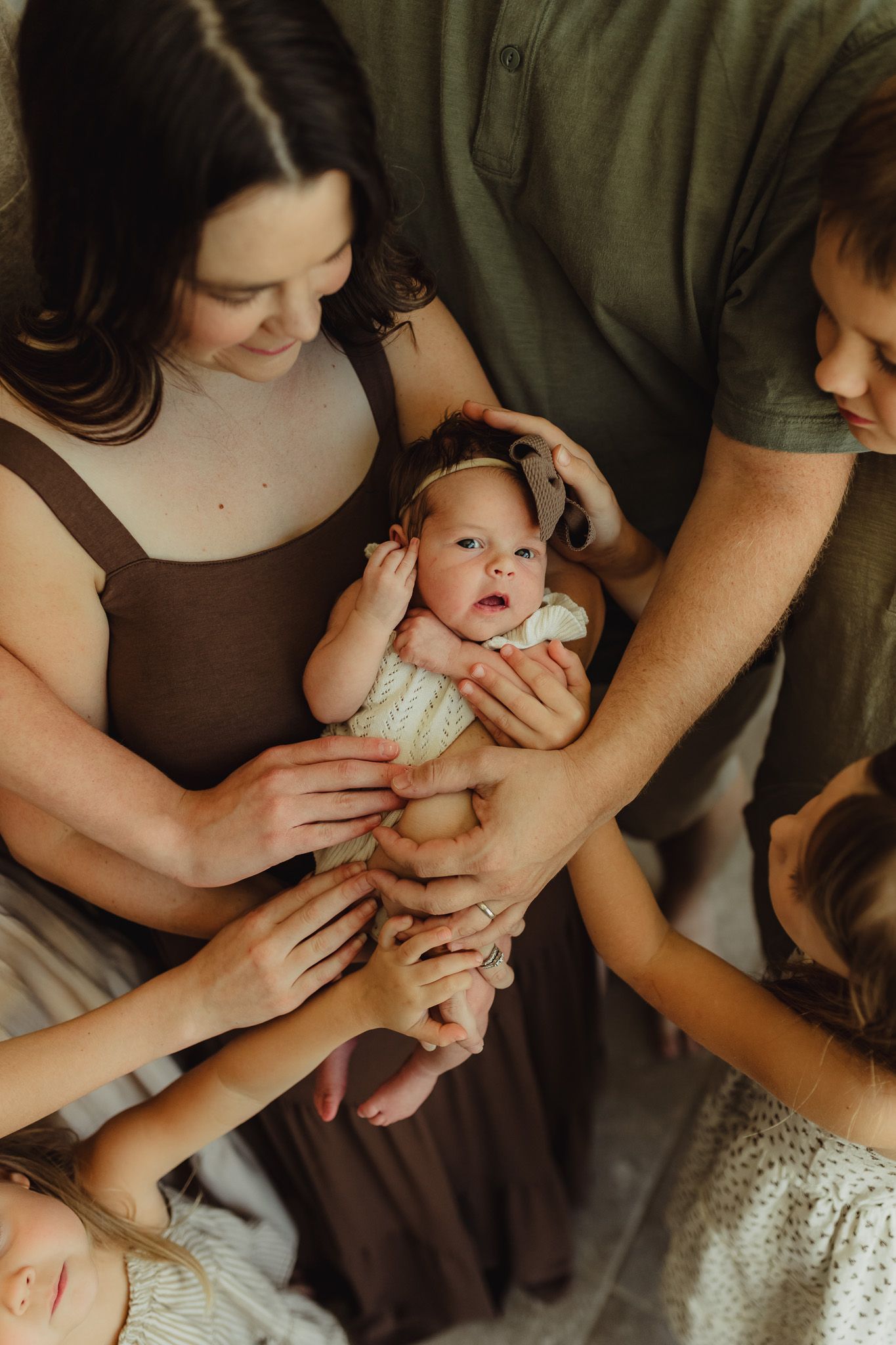 Bradenton in-home newborn photography featuring parents cuddling their newborn in a cozy lifestyle session. big family