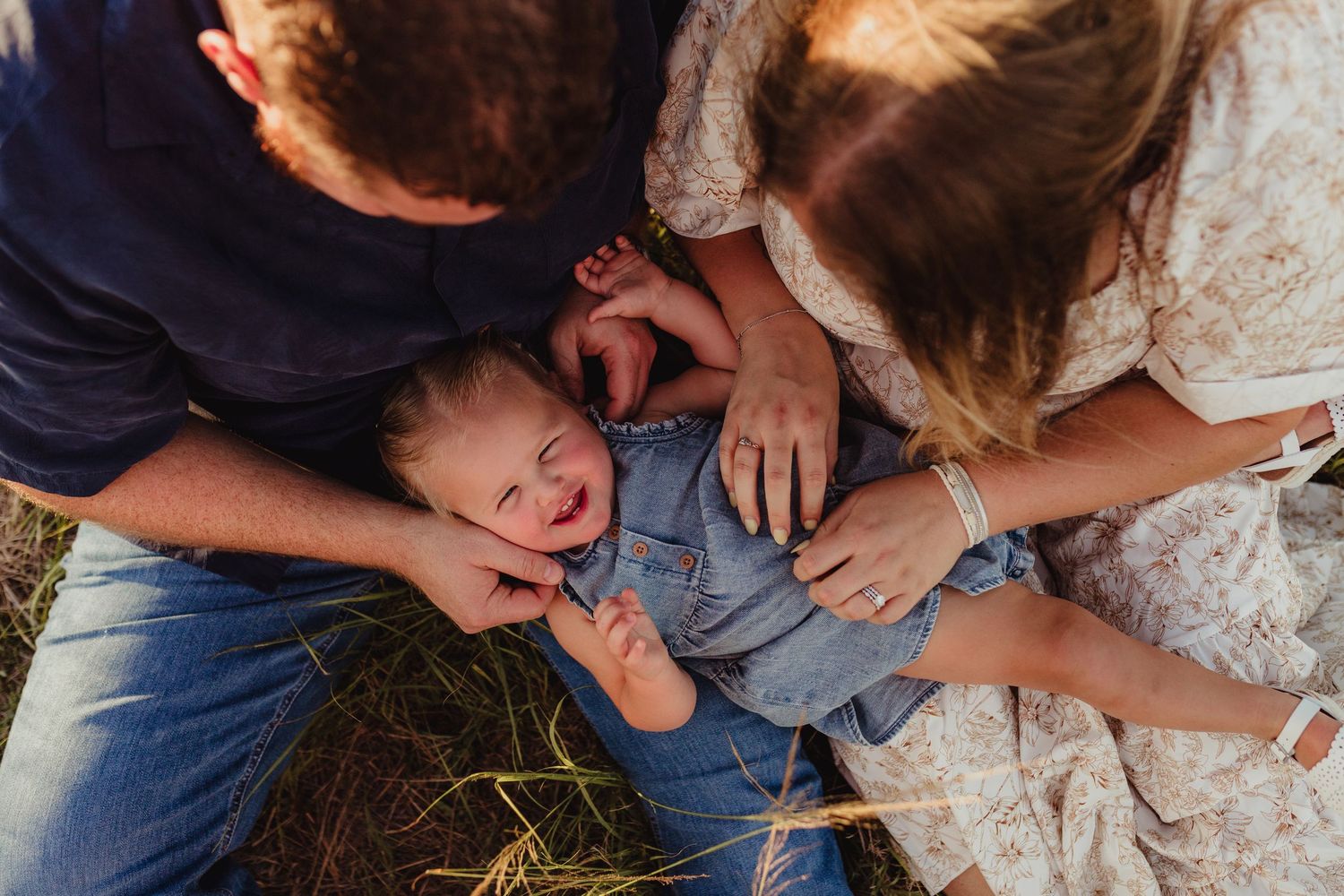 Sarasota family photography documenting authentic moments between parents and children during a golden hour session. laughing kids