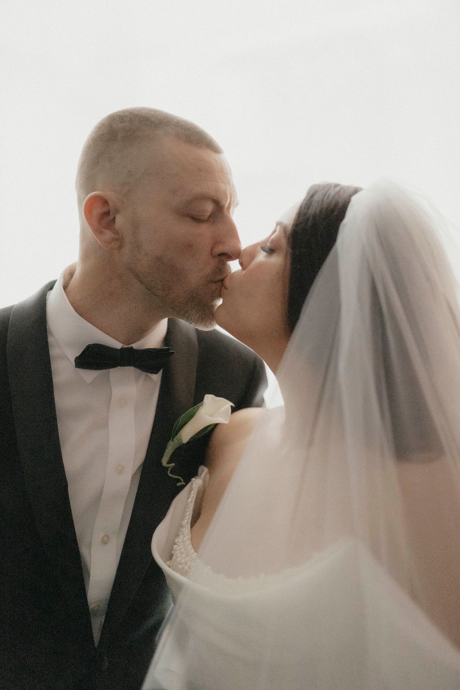 Bride and groom share a romantic kiss on their wedding day.