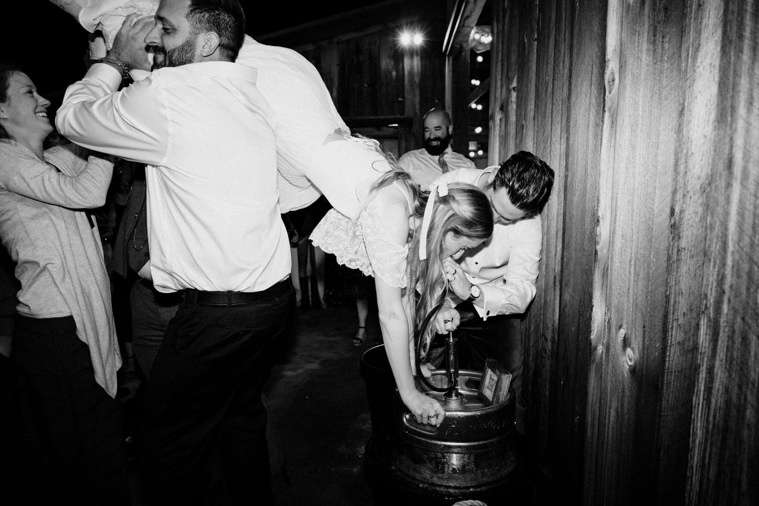 Lively black and white wedding reception dance floor scene with guests celebrating energetically indoors.