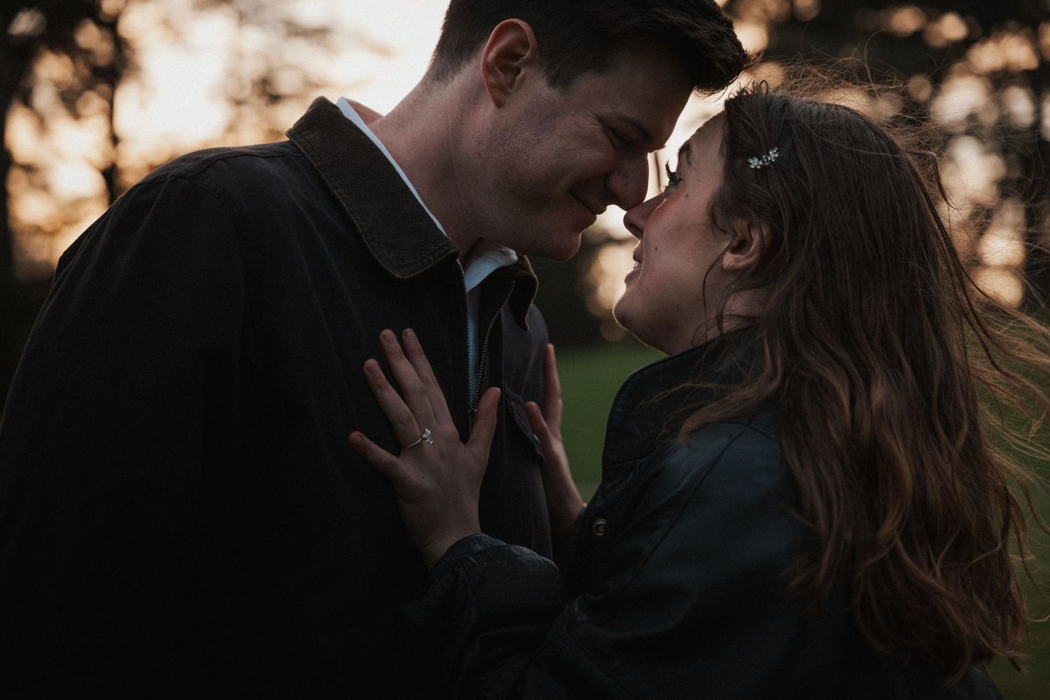 Intimate close-up of couple leaning in for a kiss in golden hour light.