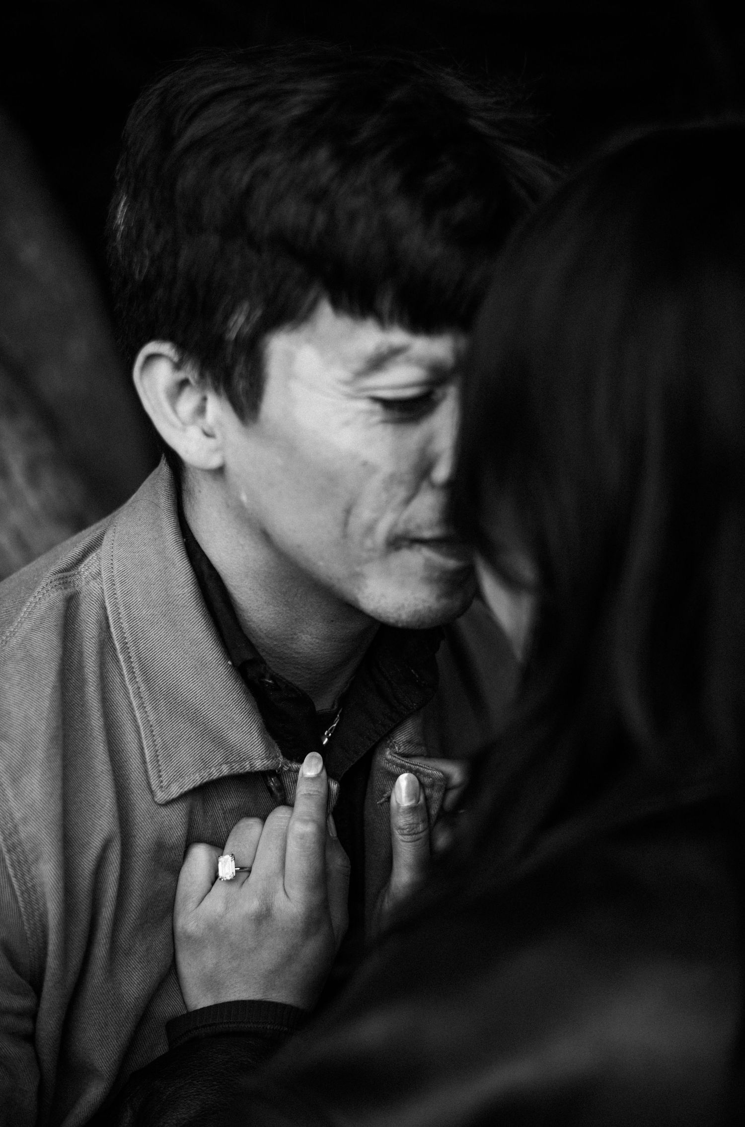 Intimate black and white portrait of a man and woman close together, her hand resting on his chest.