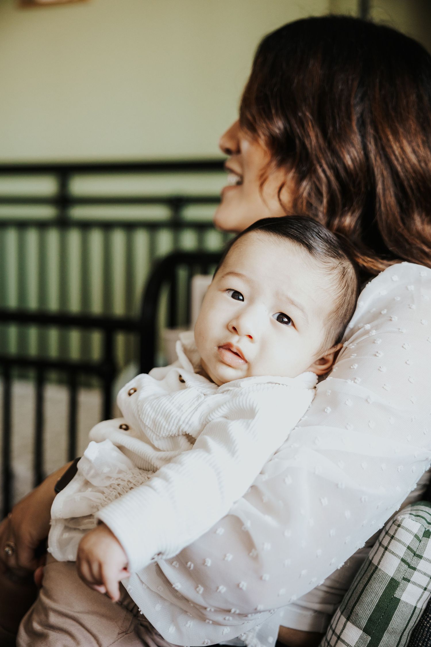 Mother tenderly holding her infant baby close to her chest.