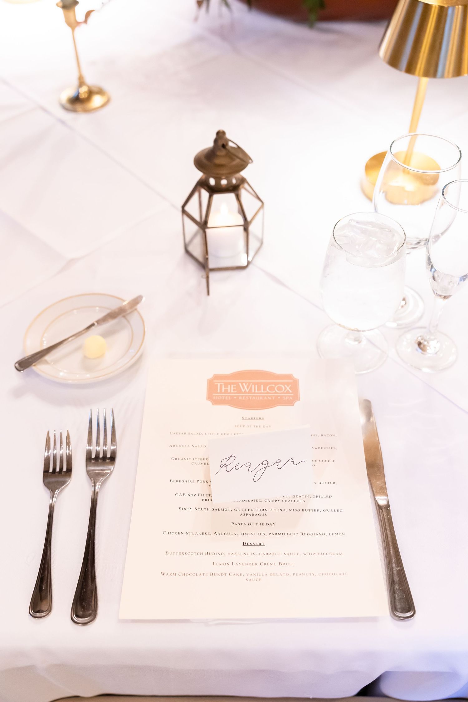Elegant wedding place setting with menu card, silverware, and glassware on white linen at The Wildcat restaurant.