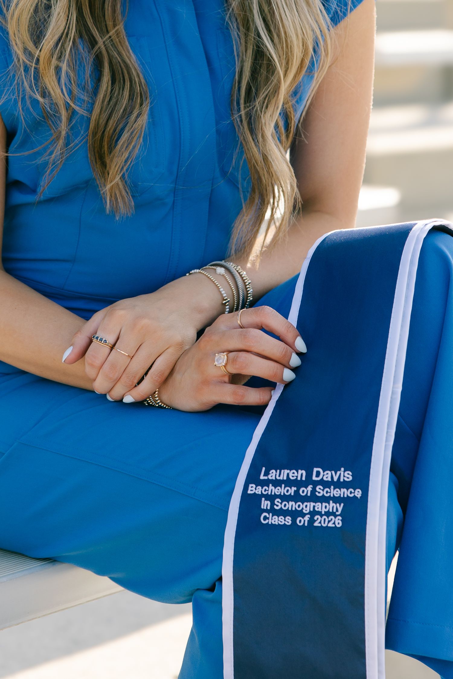 Close-up of Lauren Davis holding her Bachelor of Science in Sonography Class of 2026 graduation stole.