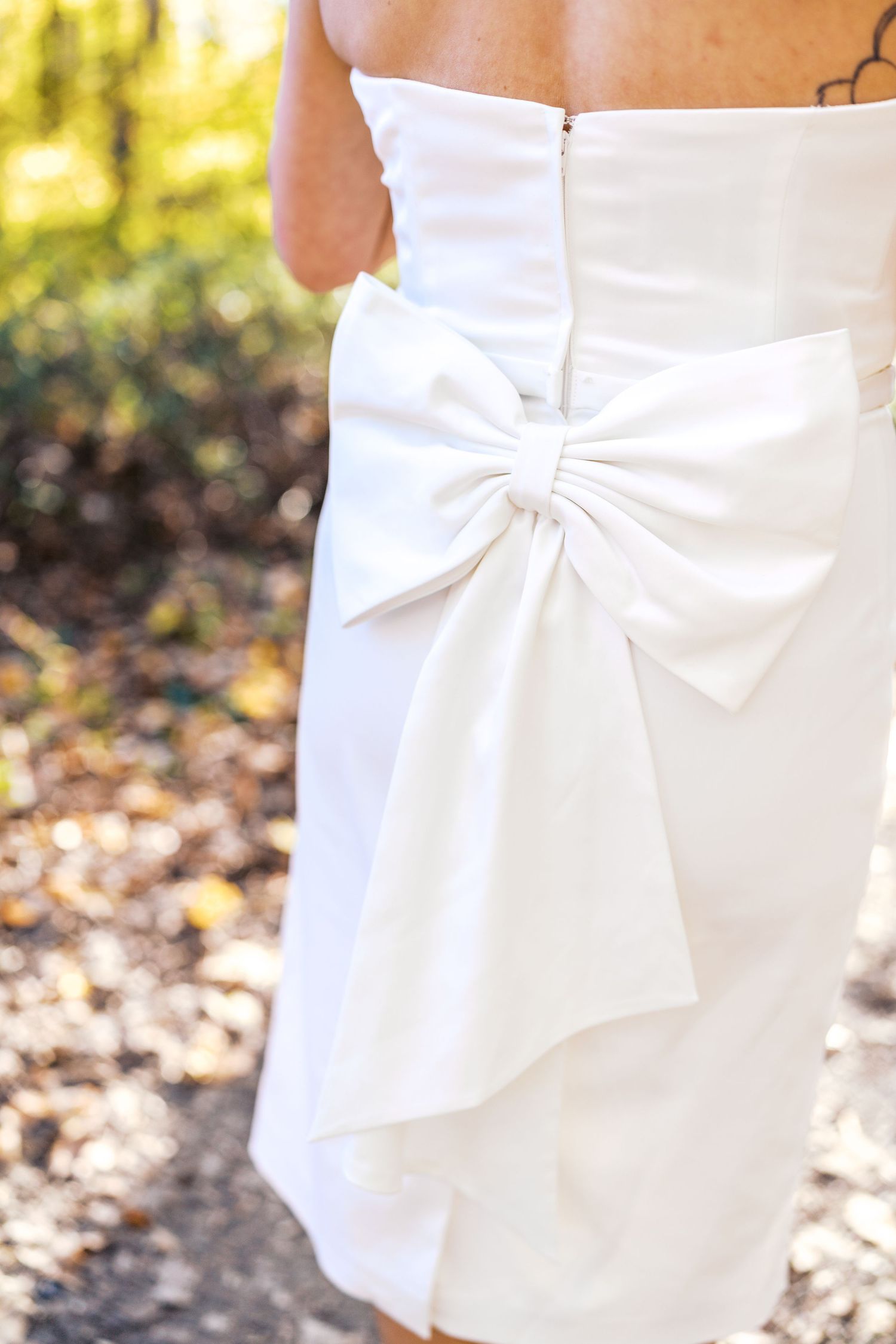 philadelphia wedding photography Close-up of a white wedding dress featuring an elegant large bow detail at the back, photographed outdoors.